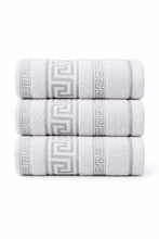 Three white towels stacked on a white background with a subtle pattern.